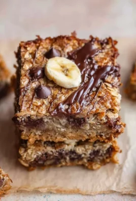 Homemade banana oatmeal bars on a wooden table with ingredients