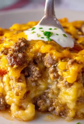 Delicious cheeseburger casserole topped with cheese and garnished with herbs
