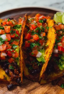 Plate of crispy black bean tacos topped with fresh ingredients