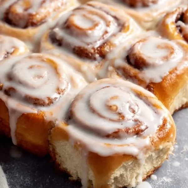 Delicious homemade cinnamon rolls with icing on a wooden board