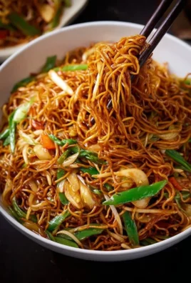 Plate of Classic Chinese Fried Noodles with vegetables and toppings.