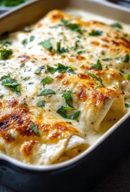 Creamy white chicken enchiladas topped with cheese and garnished with cilantro