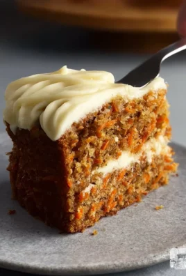 Slice of easy carrot cake with cream cheese frosting on a plate.