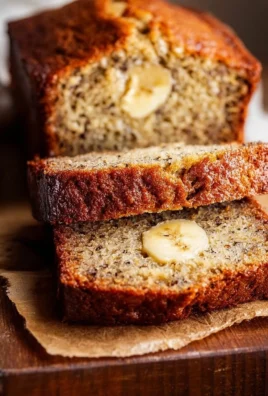 Sliced easy moist banana bread with ripe bananas on a wooden table