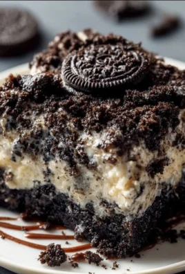Oreo dump cake topped with whipped cream and crushed Oreos on a plate