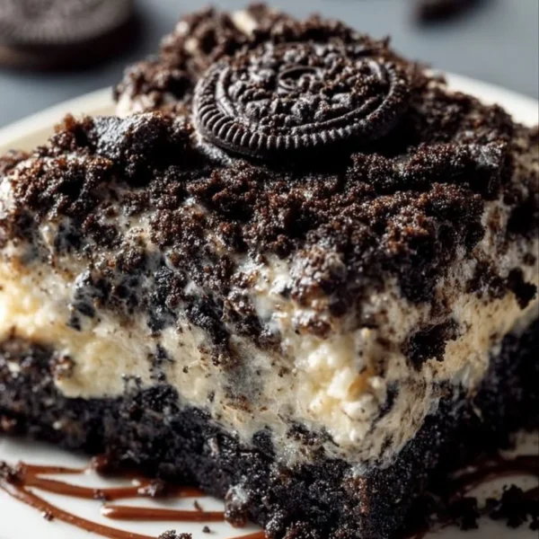 Oreo dump cake topped with whipped cream and crushed Oreos on a plate