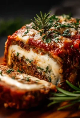 A beautifully presented stuffed Italian meatloaf on a serving platter.