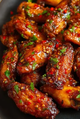 Delicious sweet and spicy chicken wings garnished with herbs