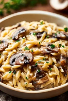 Delicious bowl of orzo with mushrooms, garnished and ready to serve.