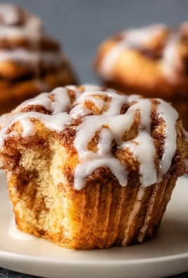 Freshly baked cinnamon roll muffins with a cinnamon swirl topping