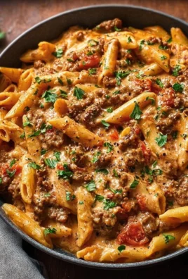 Delicious creamy beef pasta in a bowl, garnished with parsley.