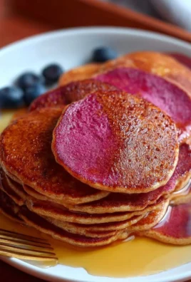 A stack of easy red pancakes with syrup and berries on a plate