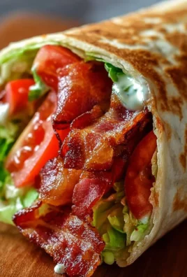 Healthy BLT wraps drizzled with secret sauce on a wooden table