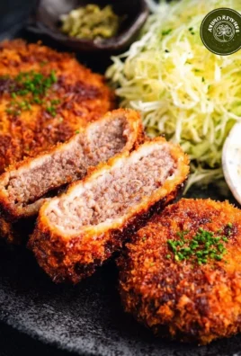 Menchi Katsu: A delicious Japanese ground meat cutlet served crispy and golden brown.