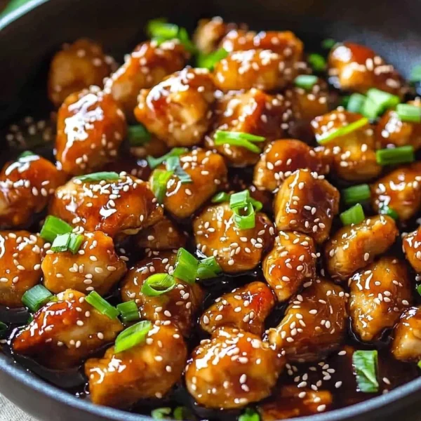 Sesame chicken dish garnished with sesame seeds and vegetables