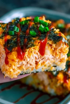 Spicy tuna and creamy crab sushi bake dish topped with green onions and seaweed