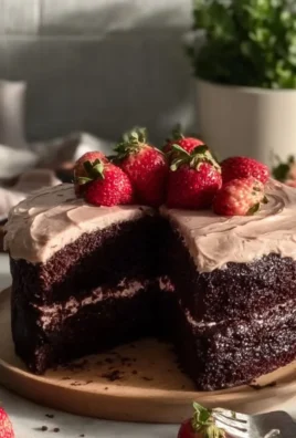 Delicious Strawberry Chocolate Cake topped with fresh strawberries and chocolate drizzle.