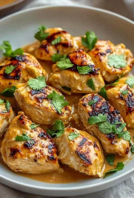 Delicious Thai Peanut Chicken served garnished with herbs and vegetables