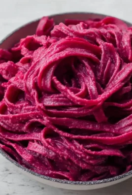 Delicious vegan beet pasta with fresh herbs and vegetables