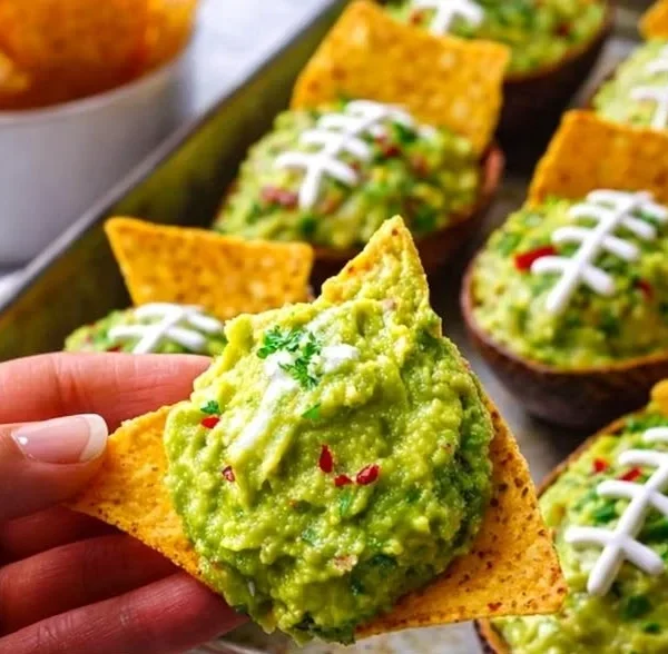 Avocado guacamole served in a football-themed bowl for gameday festivities.