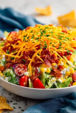 Cheesy Cobb Salad Dip served in a bowl with fresh toppings.