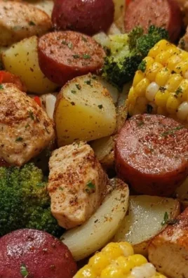 Foil packets containing chicken, sausage, potatoes, broccoli, and corn for grilling.