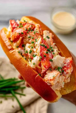 Delicious creamy lobster rolls served in a toasted bun with fresh ingredients.