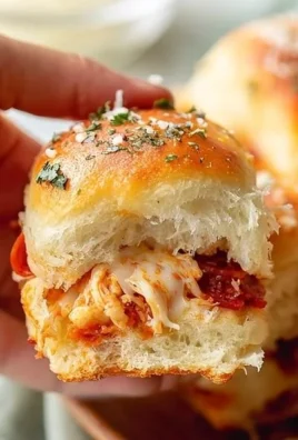 Homemade Hawaiian Roll Pizza Sliders served on a plate with pineapple and ham toppings.