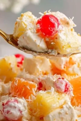 A bowl of irresistible ambrosia fruit salad with colorful fruits and creamy dressing.