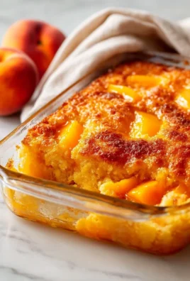 Deliciously baked juicy peach dump cake served on a plate with fresh peaches