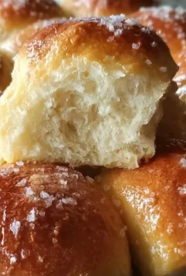 Freshly baked no-knead buttermilk dinner rolls on a wooden table