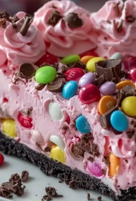 Slice of Pink M&M Snickers Cheesecake with colorful M&Ms and caramel topping