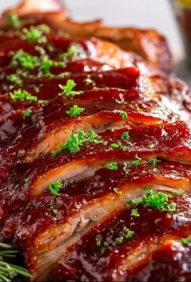 Delicious slow cooker spare ribs served on a plate with barbecue sauce.