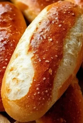 Freshly baked sourdough hot dog buns on a wooden serving board